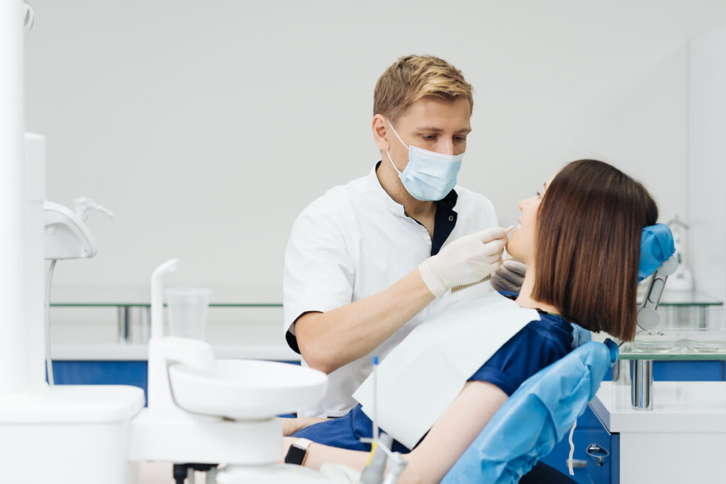 Dentysta wybiera odcień koloru zębów u pacjentki